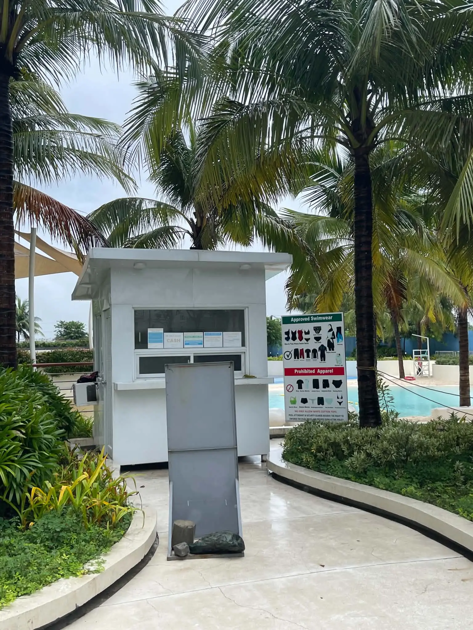 Pool kiosk with approved swimwear signage at Azure North